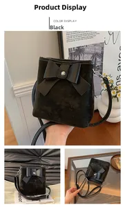 Detail of black suede bucket bag featuring a decorative bow and adjustable strap