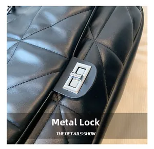 Detailed macro view of the silver metal twist lock on black quilted leather bag