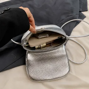 Detailed interior view of silver textured crossbody bag showing daily essentials storage