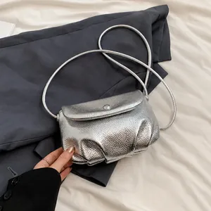Detail show of silver metallic pleated cloud bag with textured finish and snap closure