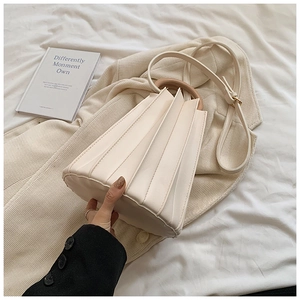 Détail du sac seau plissé blanc cassé avec poignée en bois et bandoulière réglable