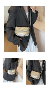 Detail of champagne gold cloud crossbody bag featuring a pearl clasp and lychee texture