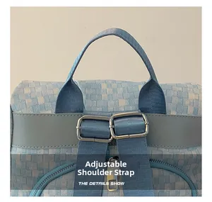 Détail du sac à dos bleu clair à carreaux avec boucles métalliques et sangles réglables