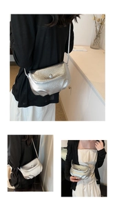 Detail of silver metallic textured crossbody bag with magnetic buckle and lychee grain