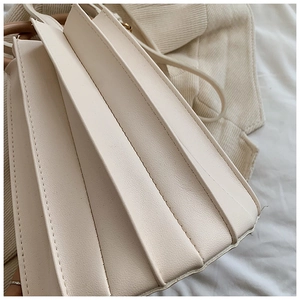 Détail des couches plissées en accordéon et des coutures sur un sac à bandoulière