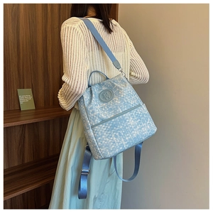 Détail de la texture à carreaux bleu et blanc du sac à dos avec motif ours et sangle
