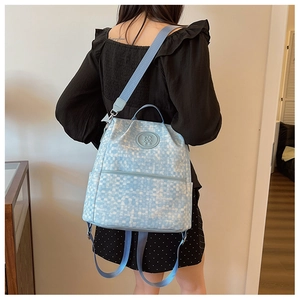Vue arrière d'un sac à dos à carreaux bleu clair avec badge d'ours sur un mannequin