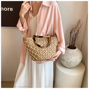 Detail of straw woven tote with vintage bamboo handles and mesh net overlay decoration