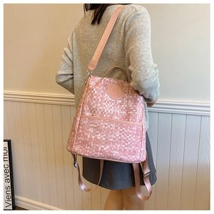Détail d'un sac à dos à carreaux roses avec écusson d'ours et sangles réglables