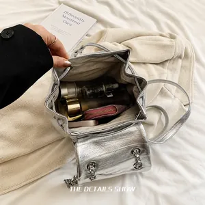 Gros plan sur l'espace intérieur du sac à dos argenté pour cosmétiques et accessoires