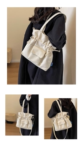 Detail of off-white canvas tote bag featuring drawstring closure and front flap pocket design