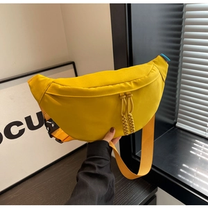 Détail du sac banane en toile jaune avec sangle orange et tirettes de zip tissées