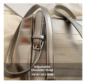 Détail du sac en cuir argenté avec bandoulière réglable et boucle en métal brillant