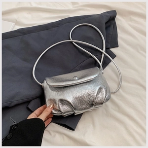 Detail of silver metallic textured PU shoulder bag with circular snap closure