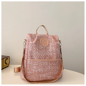 Vue détaillée du sac à dos tissé rose avec logo ours embossé et poignée de transport solide