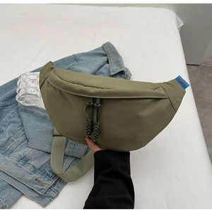 Détail du sac banane en toile vert olive avec fermetures éclair doubles et bandoulière