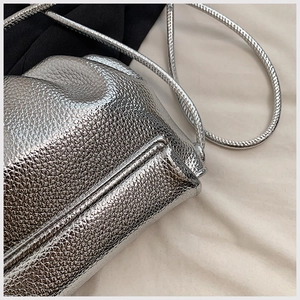 Close-up of metallic silver cloud bag showing detailed pleats and shiny leather texture