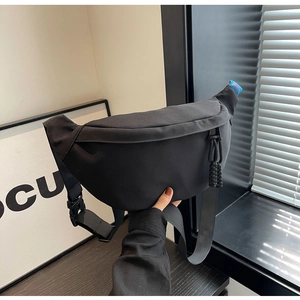 Détail du sac de poitrine en toile noire avec tirette de fermeture en corde tissée