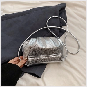 Detailed macro view of the silver metallic texture and soft pleats on this cloud crossbody bag