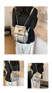 Detail of silver butterfly backpack with metallic buckle and leather chain straps