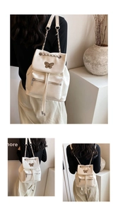 White crocodile pattern backpack with silver chain straps and metallic butterfly detail
