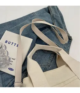 Detail view of cream canvas tote bag featuring adjustable thick shoulder strap and soft texture