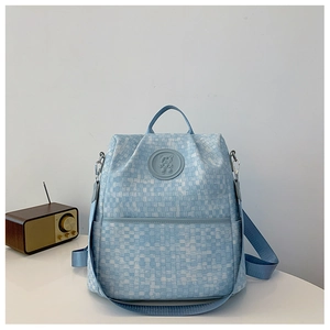 Détail du sac à dos à carreaux bleu clair avec logo ours et décor de radio rétro