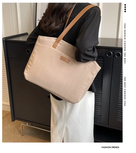 Detail of premium canvas tote bag stitching and leather branding on the side panel