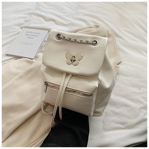 Detail of crocodile pattern cream backpack with silver chain handle and butterfly lock