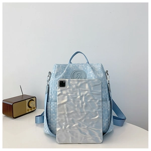 Détail du sac à dos bleu clair tissé montrant l'écusson ours et tablette pour la taille