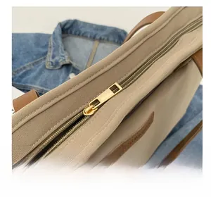 Detailed macro view of the smooth gold metal zipper closure on the canvas tote bag