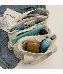 Detail of multi-layer canvas tote showing storage for tablet, phone and umbrella