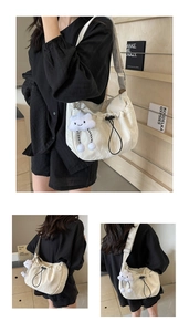 Detail of white nylon tote bag with drawstring texture and fluffy cloud pendant charm