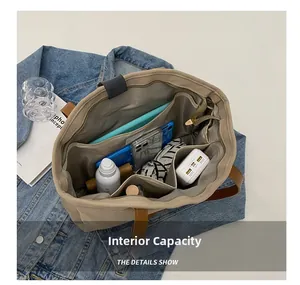 Detailed interior view of a large canvas tote bag with multi-pocket storage and leather handles