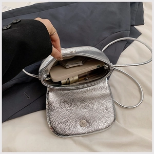 Silver textured crossbody bag detail showing interior space for phone and makeup
