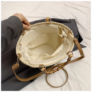 Detail view of woven bucket bag interior featuring a zipper pocket and bamboo handle