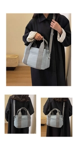 Detail view of light blue canvas multi-pocket handbag showing handles and adjustable strap