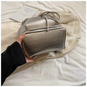 Close-up of silver backpack featuring horizontal wave embossing and metallic texture