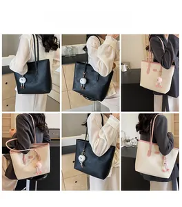Close-up of embossed pattern detail and plush pendant on stylish tote bag for women