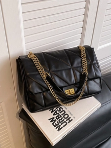 Chic black quilted shoulder bag with gold chain and flap closure in urban setting