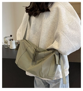 Dettaglio della borsa a tracolla in nylon grigio-verde con zip in corda e tasca laterale