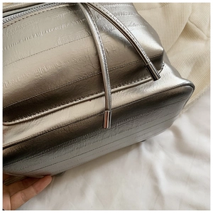 Close-up of metallic silver pleated fabric on a modern backpack with drawstring detail