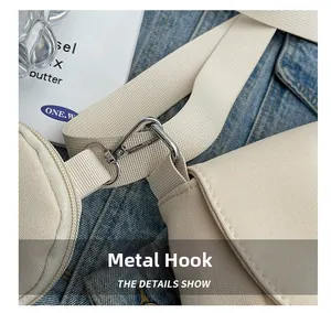 Detailed shot of durable silver hardware hook attached to beige canvas shoulder strap