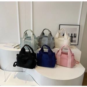 Group display of colorful large-capacity canvas tote bags on a minimalist stand