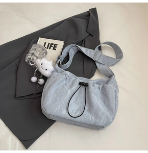 Detail of light blue pleated nylon drawstring bag with a cute white cloud charm