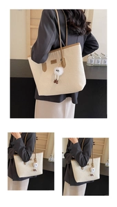 Detail of embossed cartoon patterns on beige tote bag with cute plush keychain