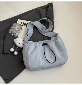 Light blue pleated nylon shoulder bag with cute plush cloud charm and black drawstring buckle