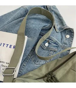 Dettaglio borsa a tracolla in nylon verde militare con spallina larga e doppia zip