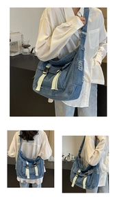 Detail of vintage denim messenger bag with frayed edges and dual white strap buckles