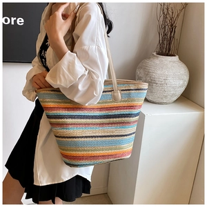 Detail of colorful striped woven tote bag with beige leather shoulder handles